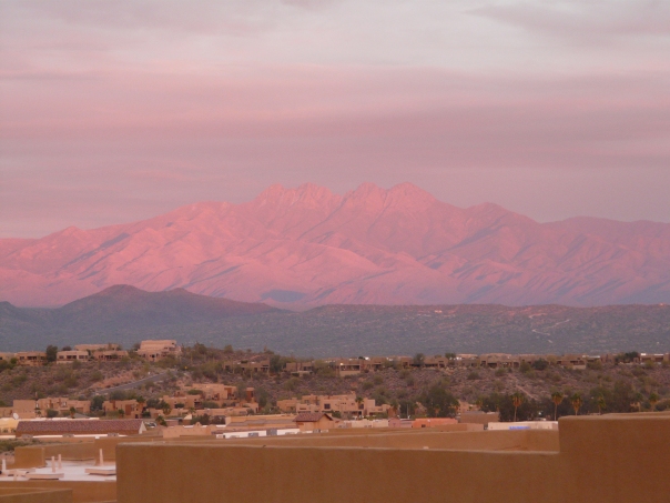 Mountains bathed in sunset light viewed from the warmth of a desert climate